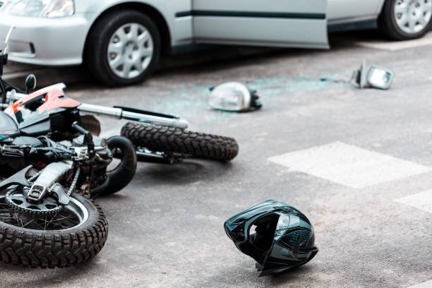 Overturned motorcycle and helmet on the street after collision with the car